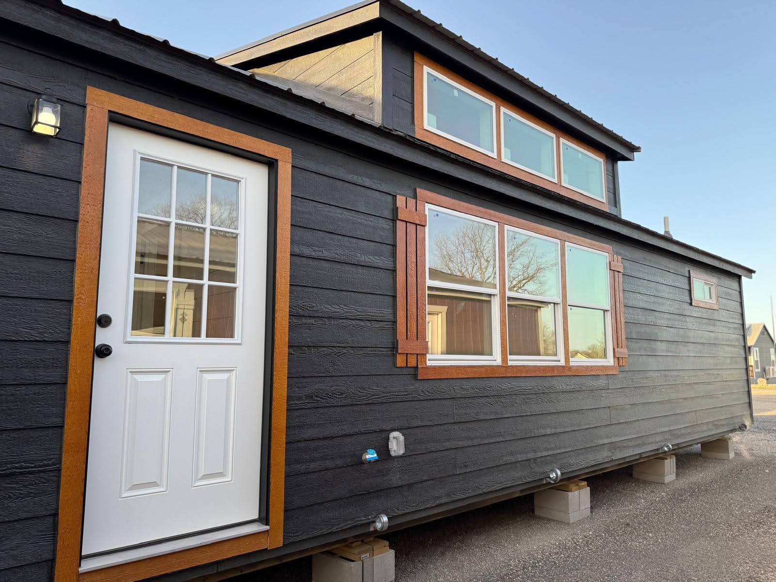 Wolf Valley cabin with dark siding, warm wood trim and large windows
